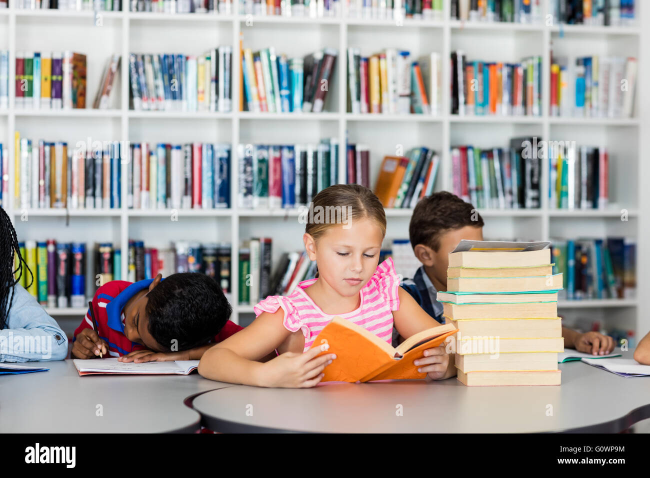 Une petite fille lisant des livres Banque D'Images