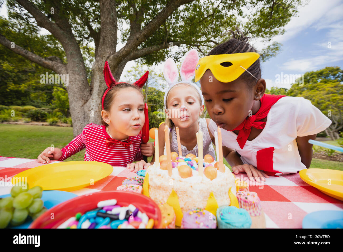 Trois petites filles ensemble de soufflage de bougies d'anniversaire Banque D'Images