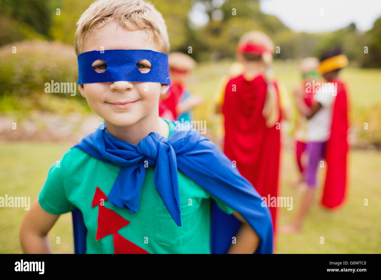 Little Boy wearing superhero costume posant pour l'appareil photo Banque D'Images
