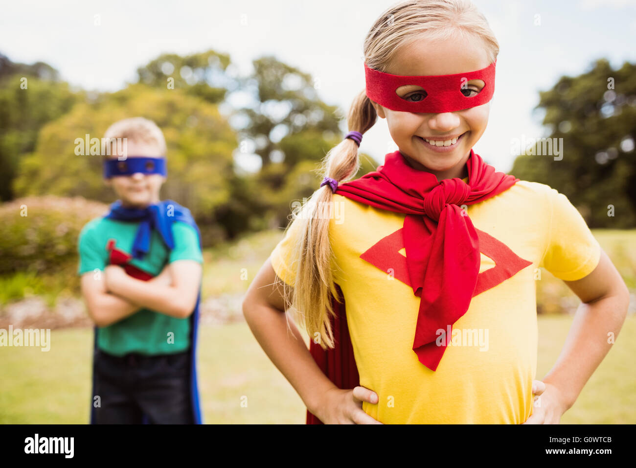 Enfants wearing superhero costume posant pour l'appareil photo Banque D'Images