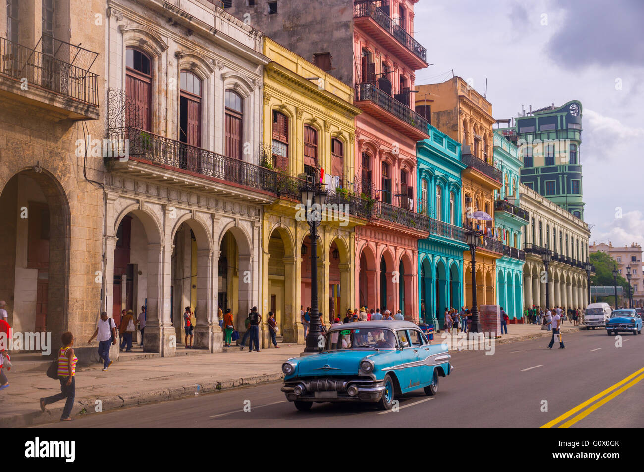 Un taxi oldtimer bleu est la conduite dans Habana Vieja devant une façade colorée de bâtiments coloniaux - La Havane, Cuba en décembre Banque D'Images