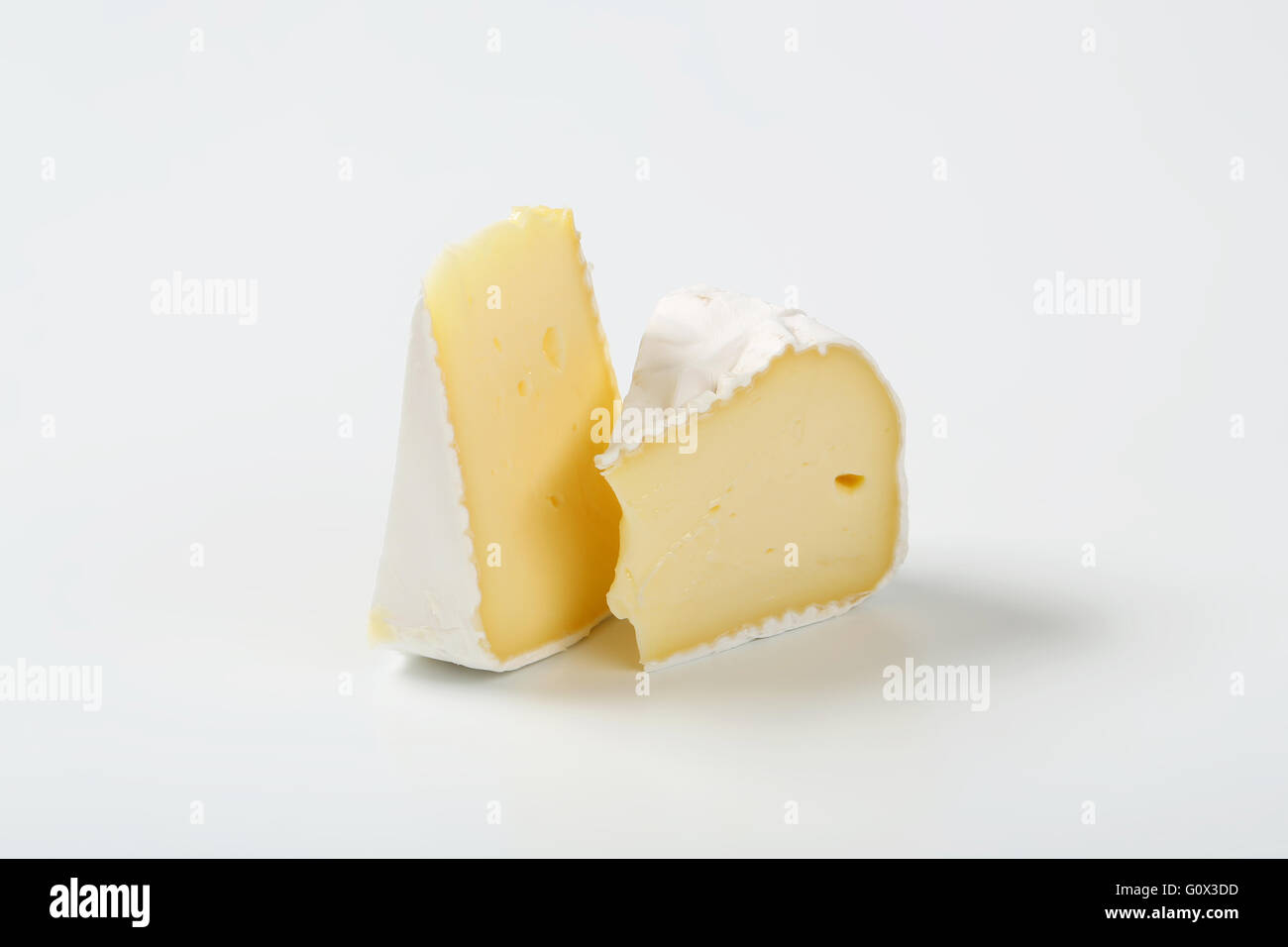 Deux tranches de fromage à croûte blanche sur fond blanc Banque D'Images