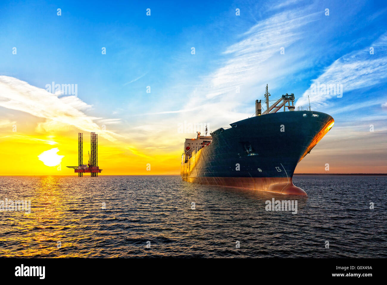 Navire-citerne et de l'huile sur la plate-forme de la zone extracôtière au coucher du soleil. Banque D'Images