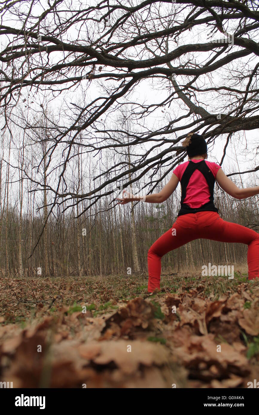 Belle femme forte fait yoga asana dans la forêt au printemps Banque D'Images