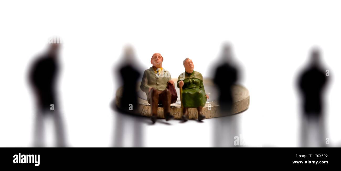 Une figurine miniature couple âgé assis sur un pound coins en face de 4 hommes hors foyer Banque D'Images