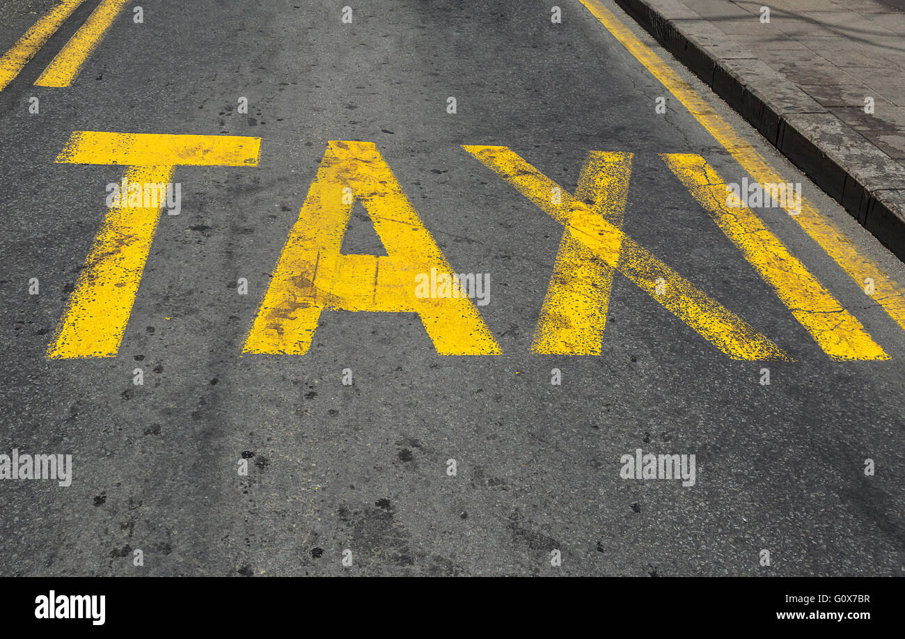 Panneau de circulation taxi jaune peint sur route asphaltée. Banque D'Images