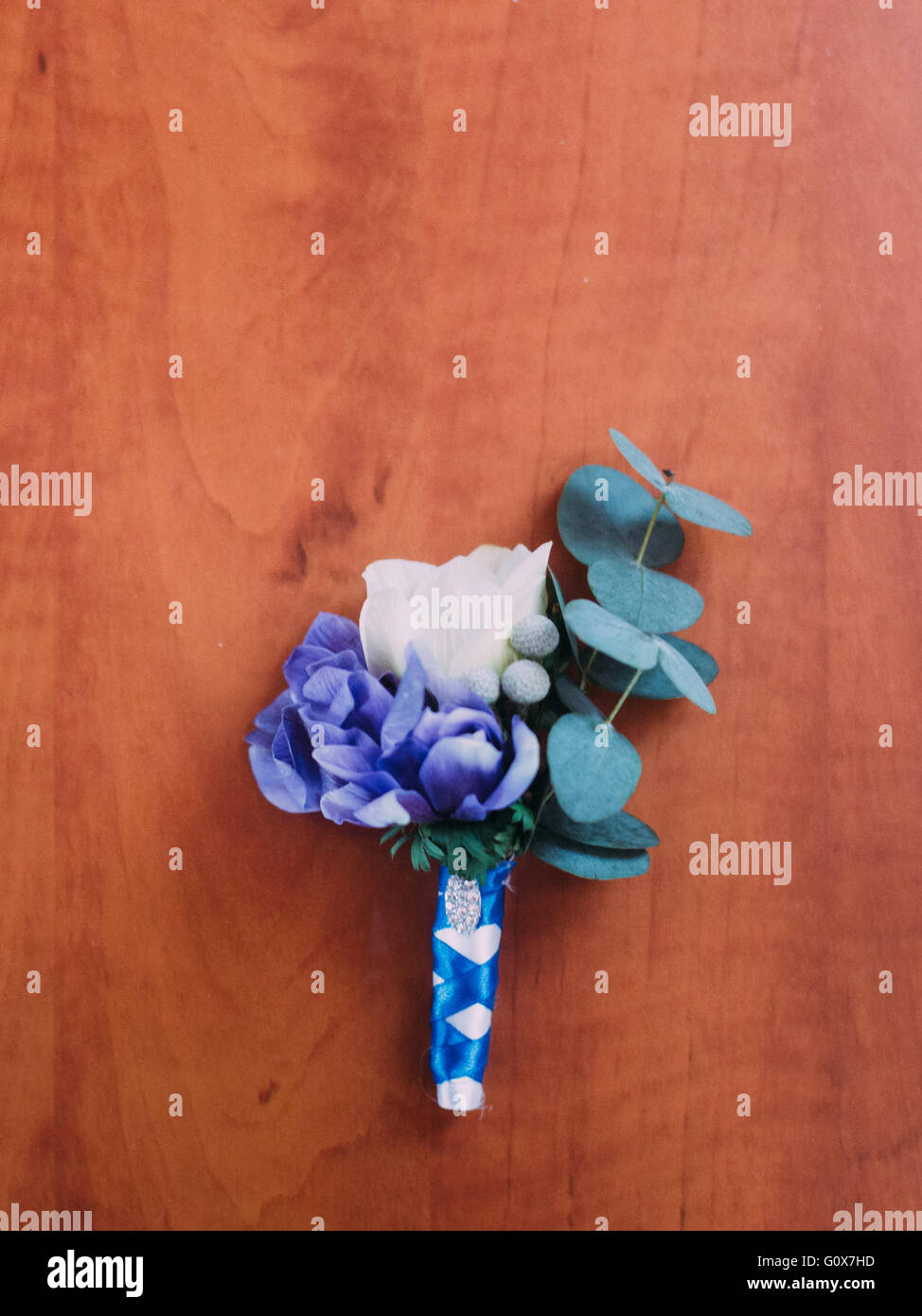 Boutonnière de mariage mignon avec des fleurs blanches ou violettes en fond de bois. Banque D'Images
