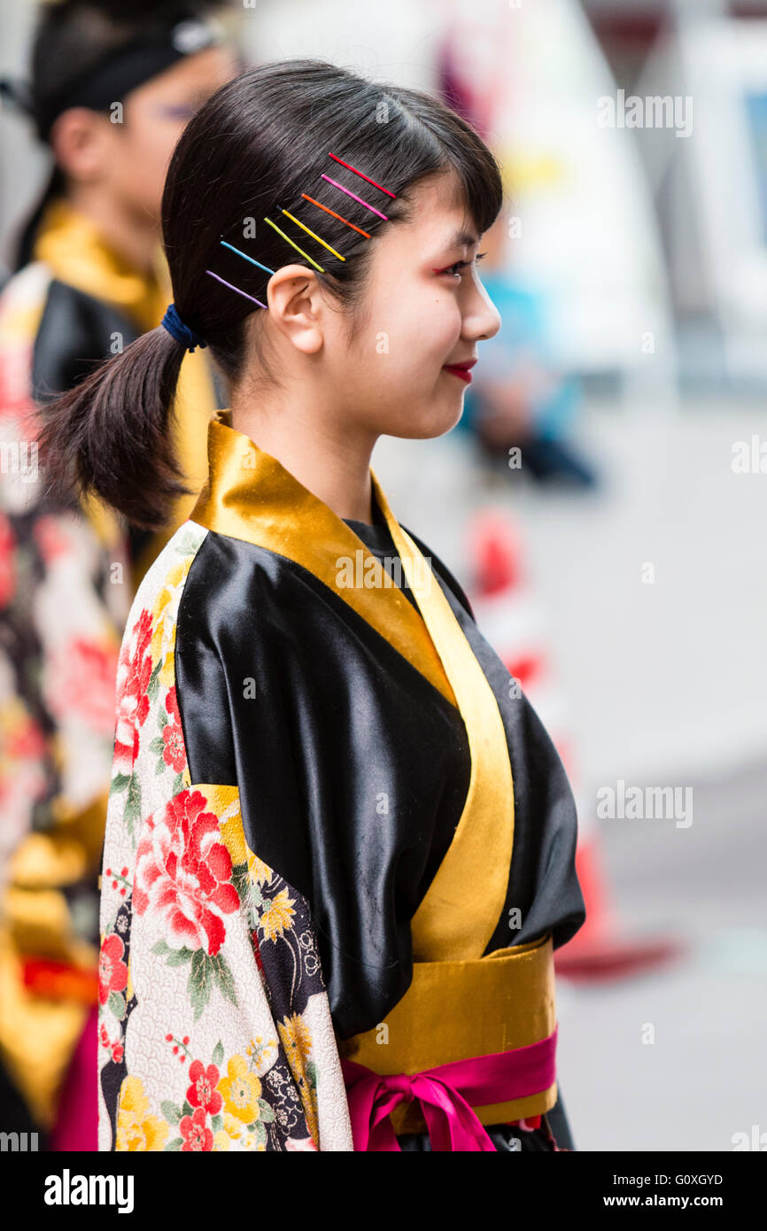 Yosakoi Festival de danse japonaise. Enfant, jeune fille, 8-9 ans, danseuse, en noir et jaune yukata, partie d'une équipe de danse. Close up, vue de côté. Banque D'Images