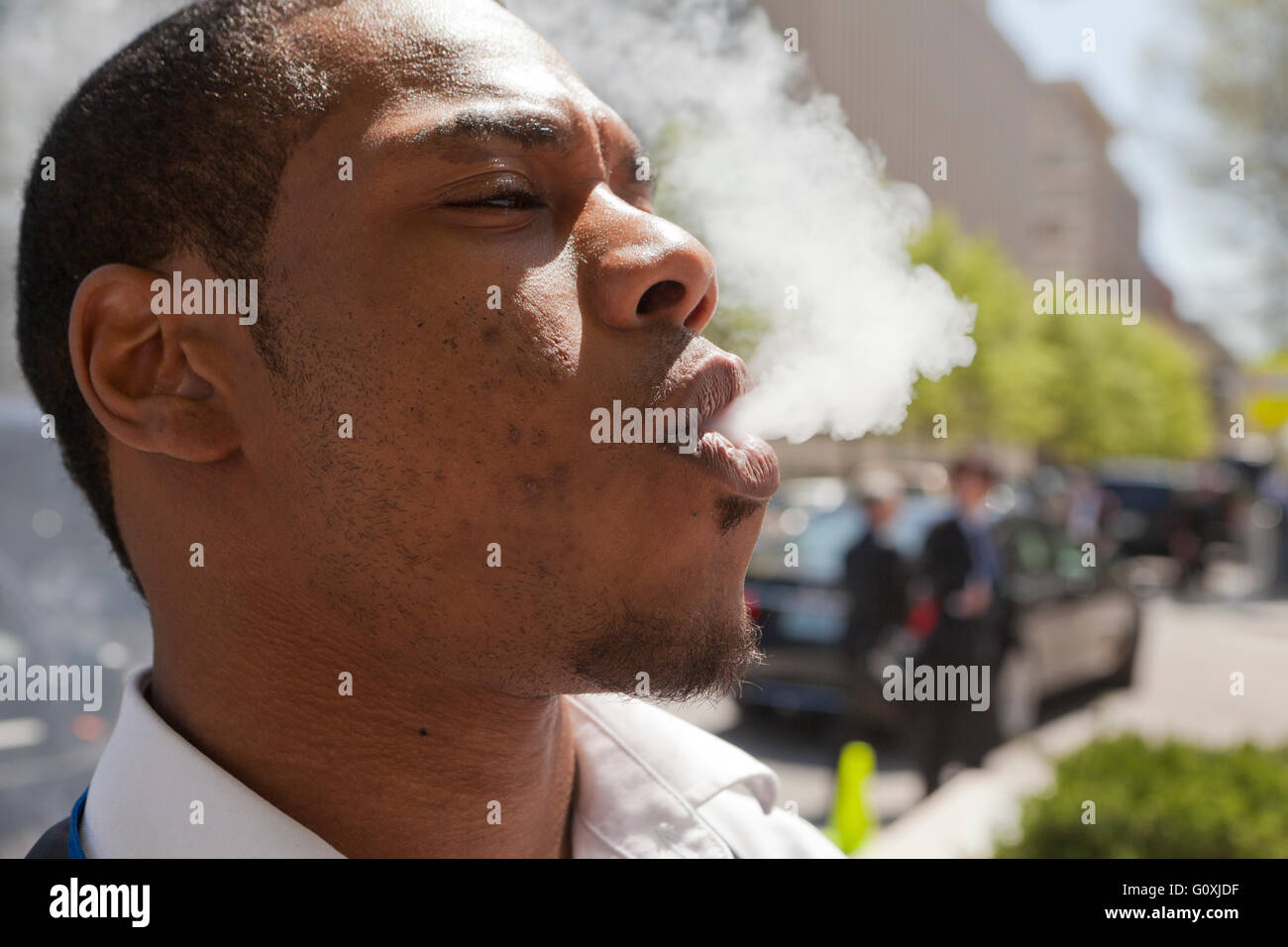 Jeune homme afro-américain de vapeurs de soufflage - USA Banque D'Images