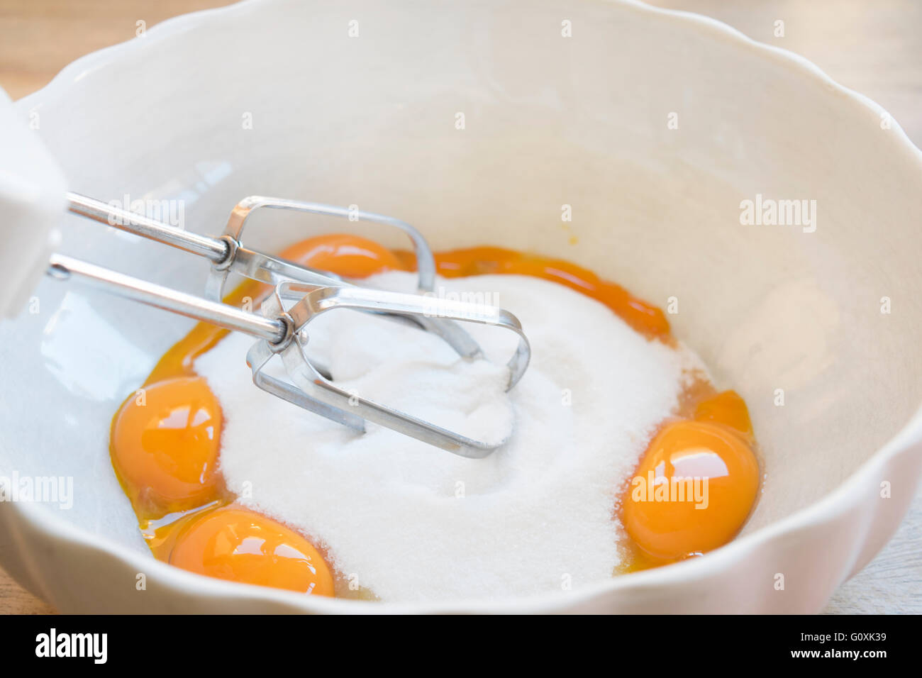 La préparation d'un gâteau avec des œufs du sucre et des aliments-mixer Banque D'Images
