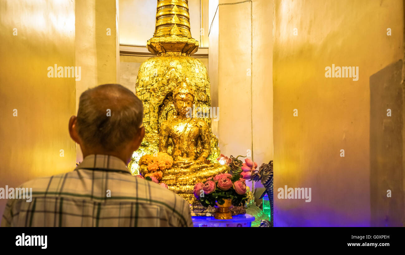 Praticien laïcs bouddhistes devant un autel d'or Banque D'Images