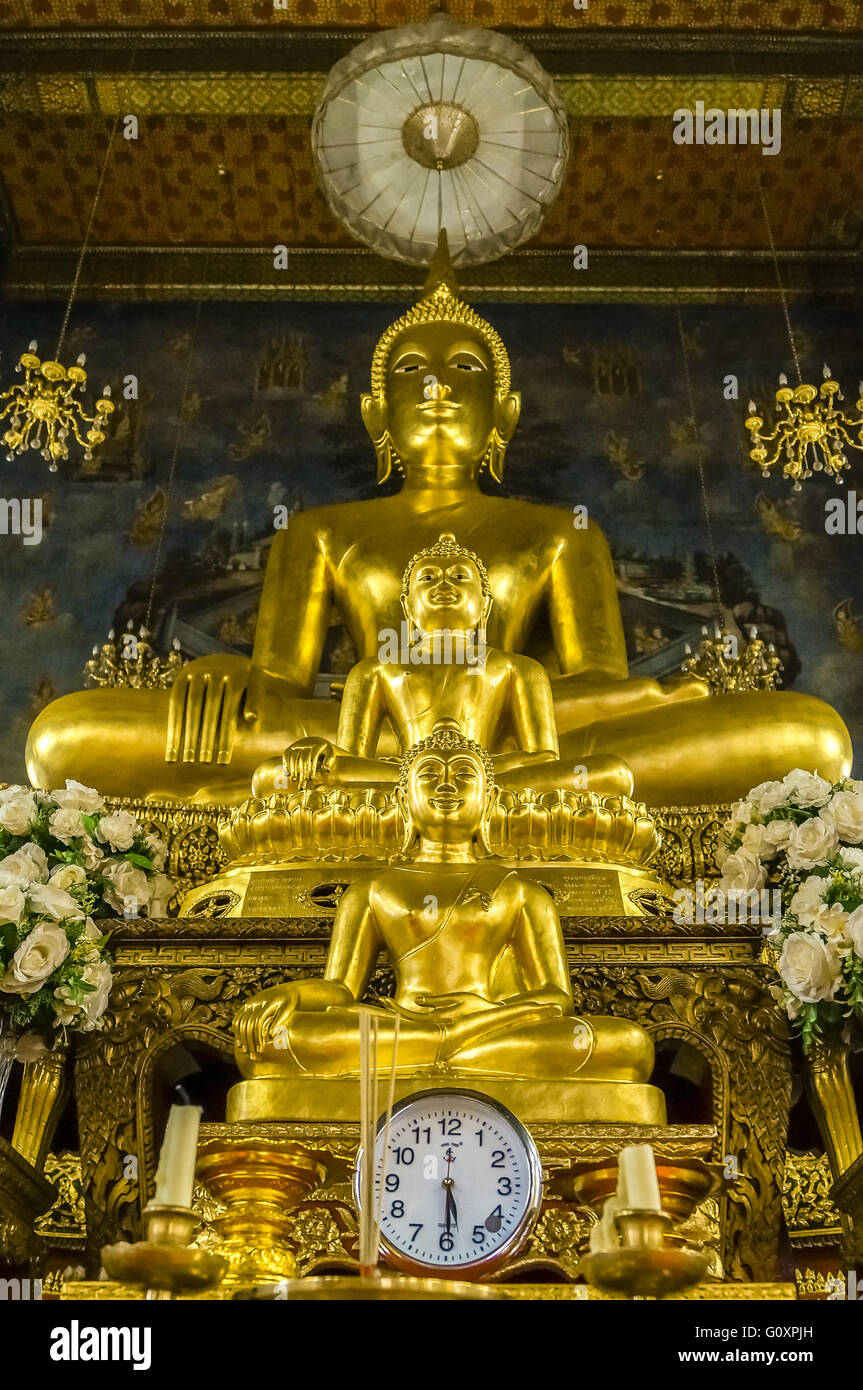 3 statues de Bouddha de différentes tailles ont été disposées sur le dessus  de l'autre. Au bas de la photo d'un grand round watch Photo Stock - Alamy