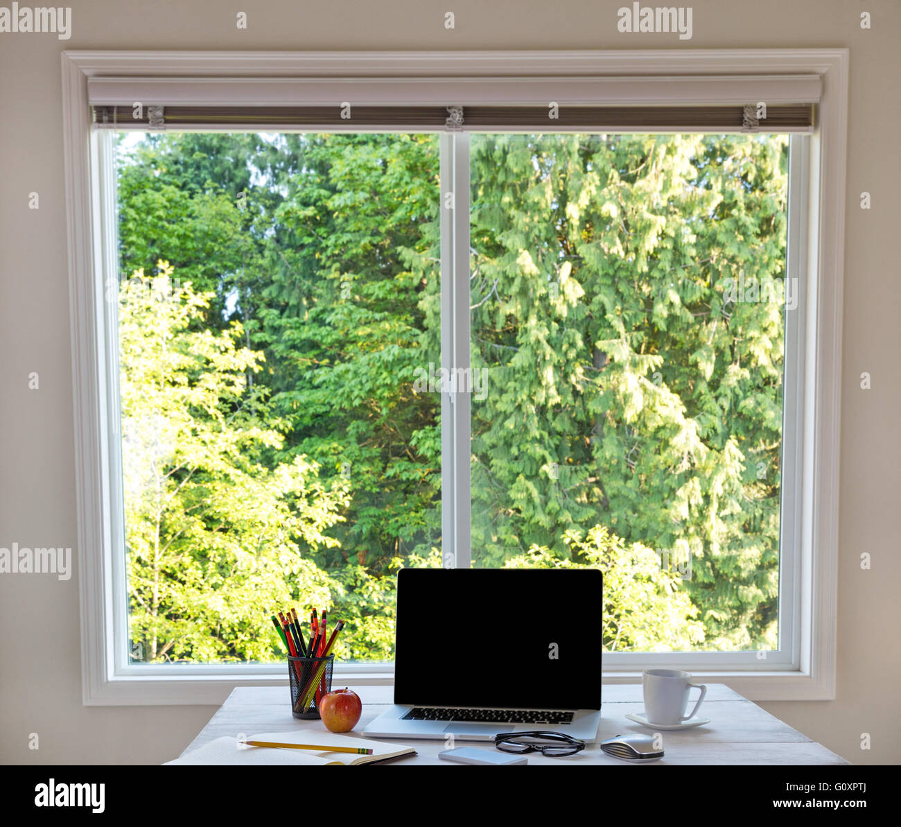 Bureau organisé en face de grande fenêtre avec lumière du jour et arbres en  arrière-plan Photo Stock - Alamy