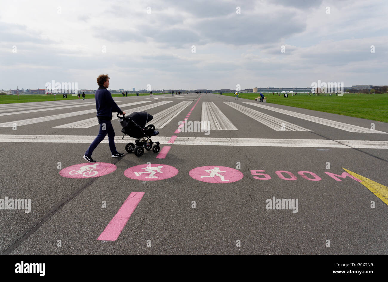 Un homme poussant une poussette sur la piste de l'aérodrome de Tempelhof park à Berlin, Allemagne Banque D'Images
