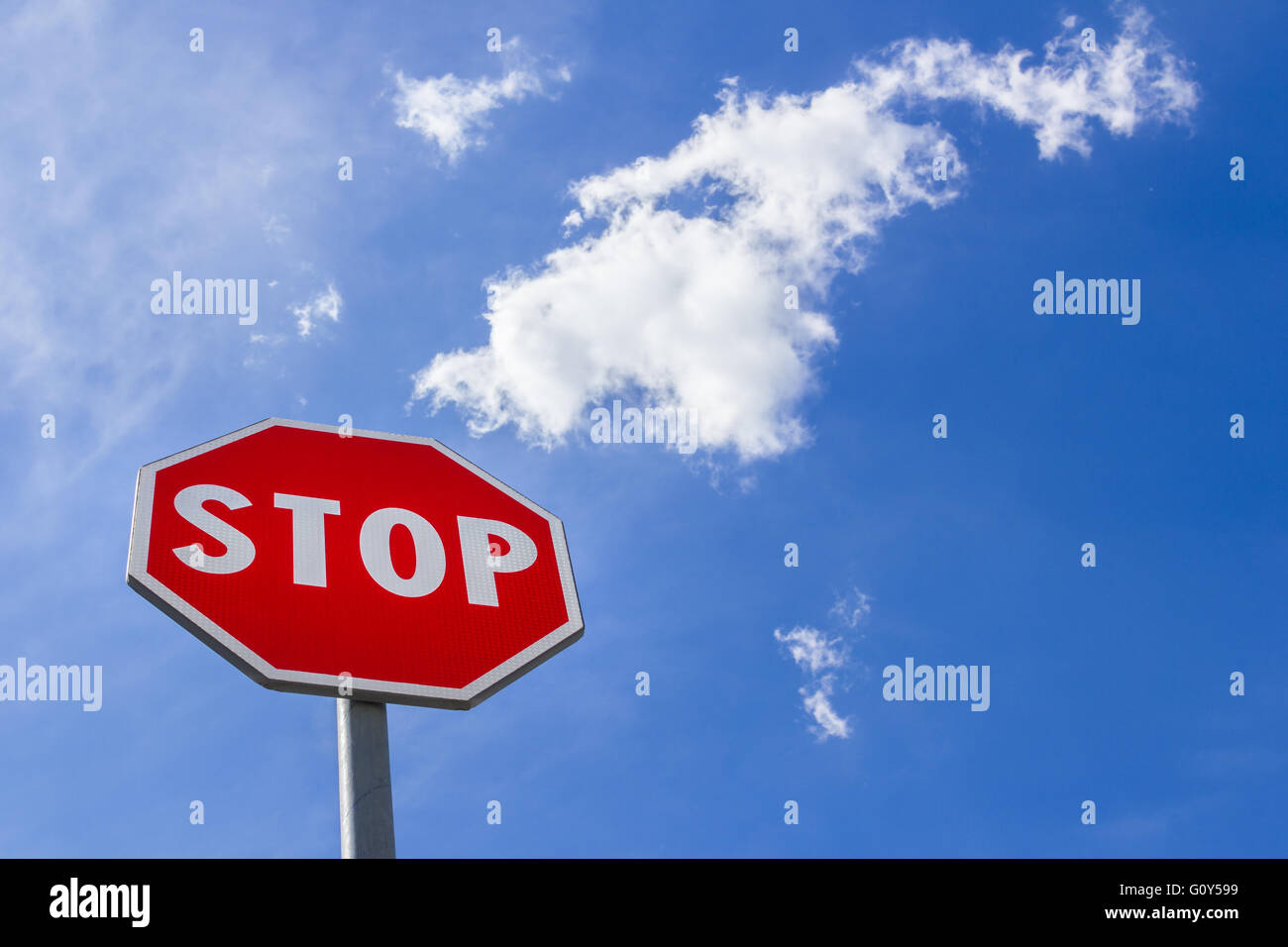 Un panneau d'arrêt contre un ciel bleu. Banque D'Images