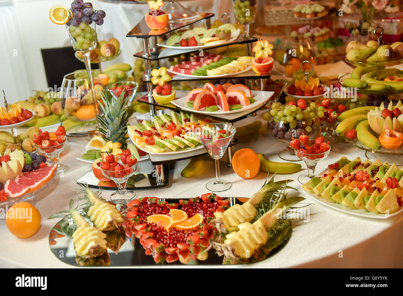 Plaques avec différents types de fruits : raisin, fraise, ananas, orange, grenade, kiwi, banane Banque D'Images