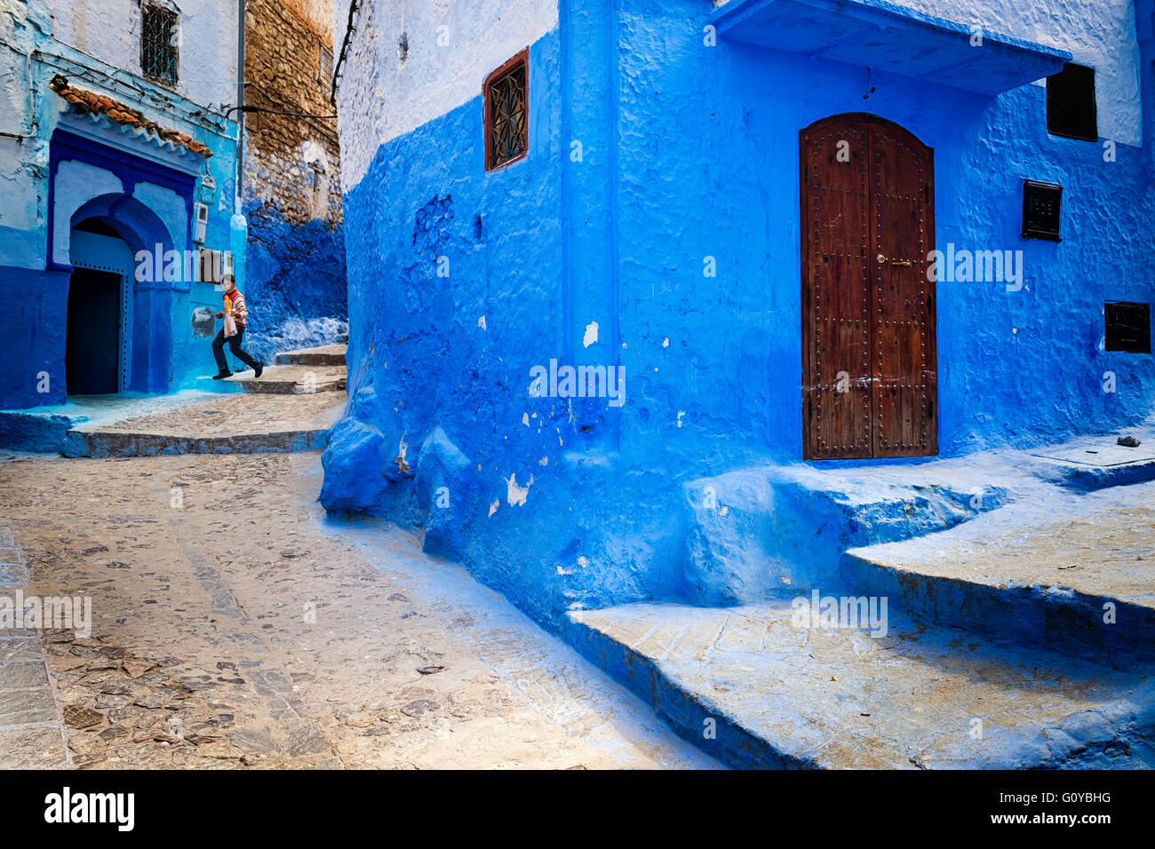 Chefchaouen, Maroc - 10 Avril 2016 : un enfant s'exécutant dans une rue de la ville de Chefchaouen au Maroc. Banque D'Images
