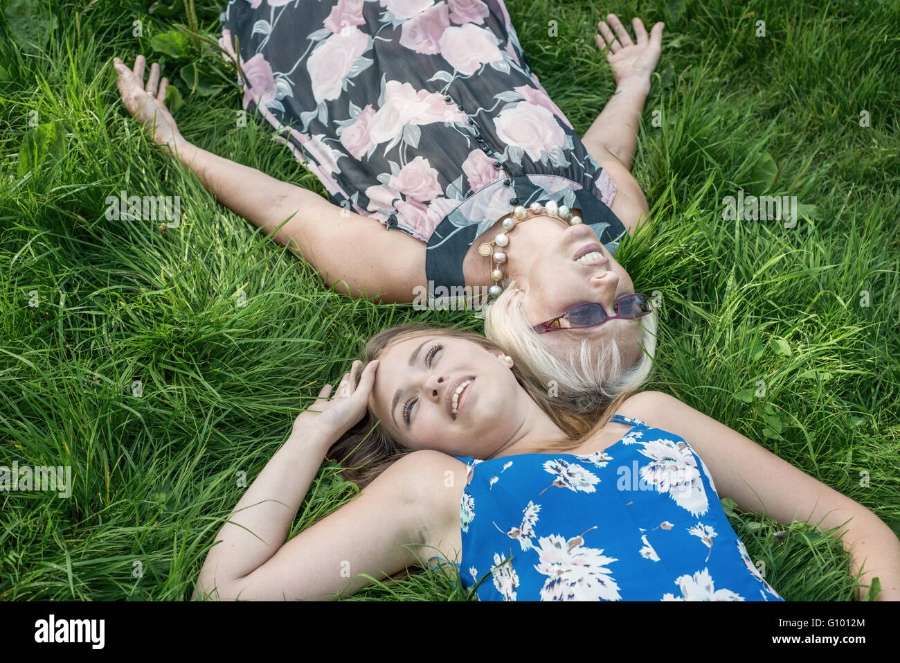 Deux femmes de générations différentes se trouvent sur l'herbe. Mère et fille. Grand-mère et sa petite-fille Banque D'Images