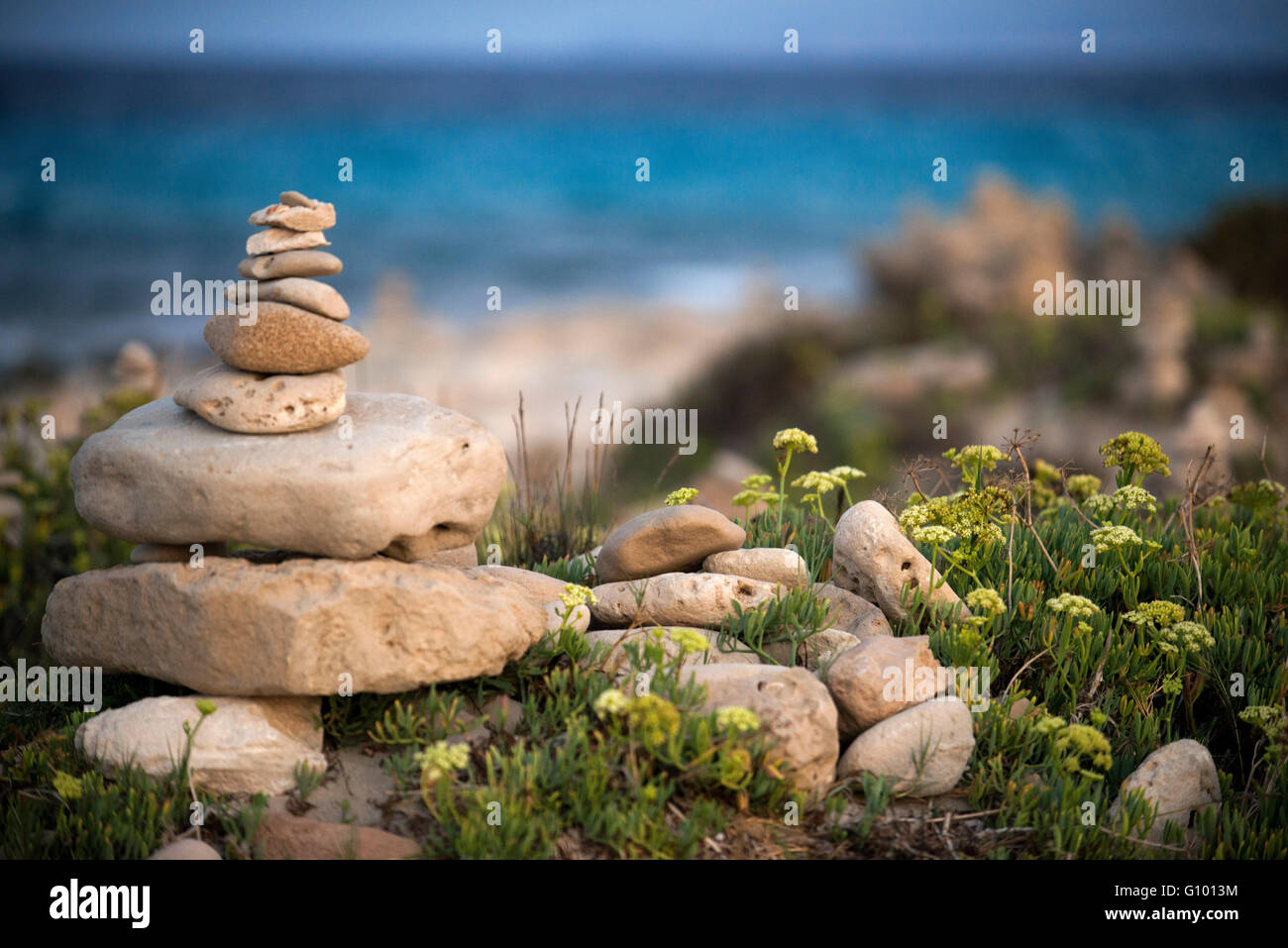 L'espace Zen. Des pierres. Plage de Ses Illetes, Îles Baléares, Formentera, Espagne. Rétroéclairages dans le coucher du soleil avec des pierres de formes différentes. 'Le déluge' ('La Riada'), un espace unique construite avec des pierres par l'allemand Johannes Schultz. Banque D'Images