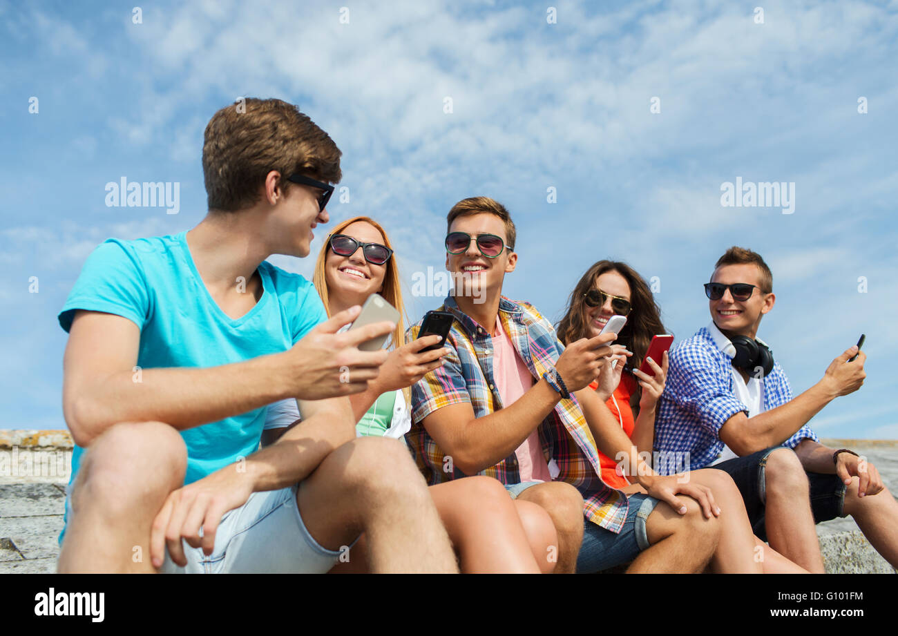 Groupe d'amis heureux avec les smartphones en plein air Banque D'Images