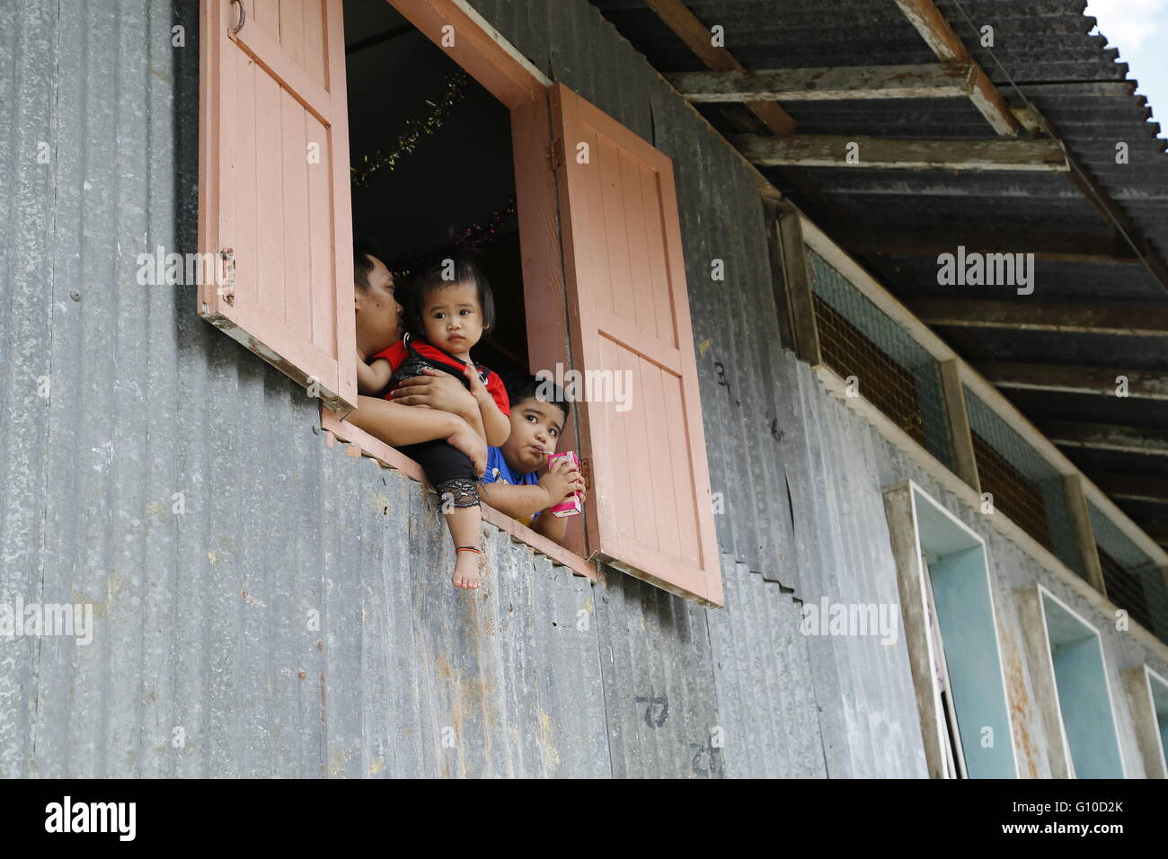 Longue maison village de Sarawak en Malaisie. Le père et les enfants autochtones du Sarawak donne de la maison longue fenêtre en bois. Banque D'Images