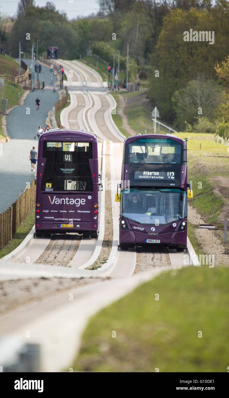 Deux bus à impériale passant sur le nouveau béton busway guidé Banque D'Images