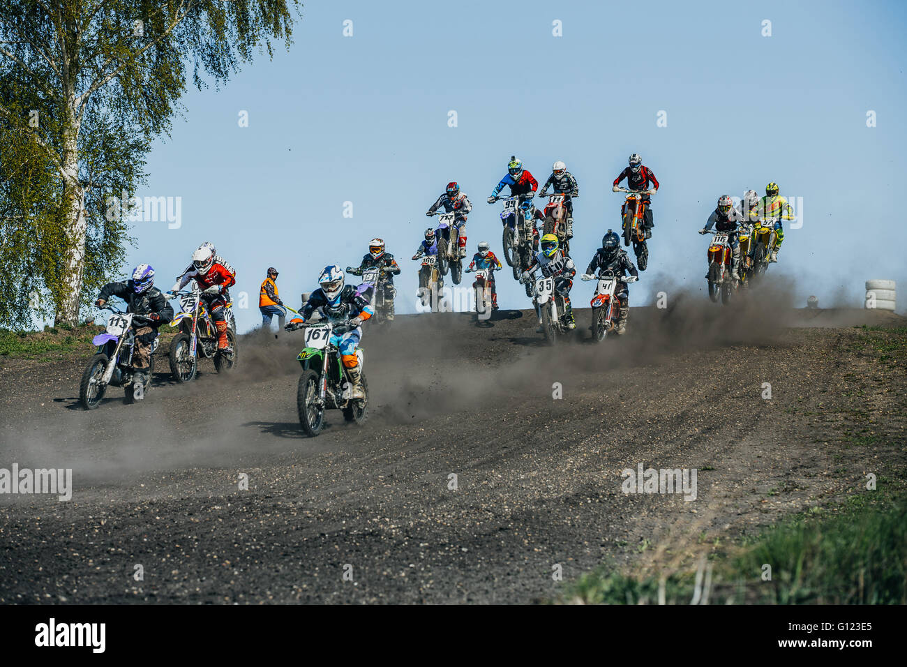 Grand groupe de coureurs sur tour de moto avec des montagnes au cours de tasse de motocross de l'Oural Banque D'Images