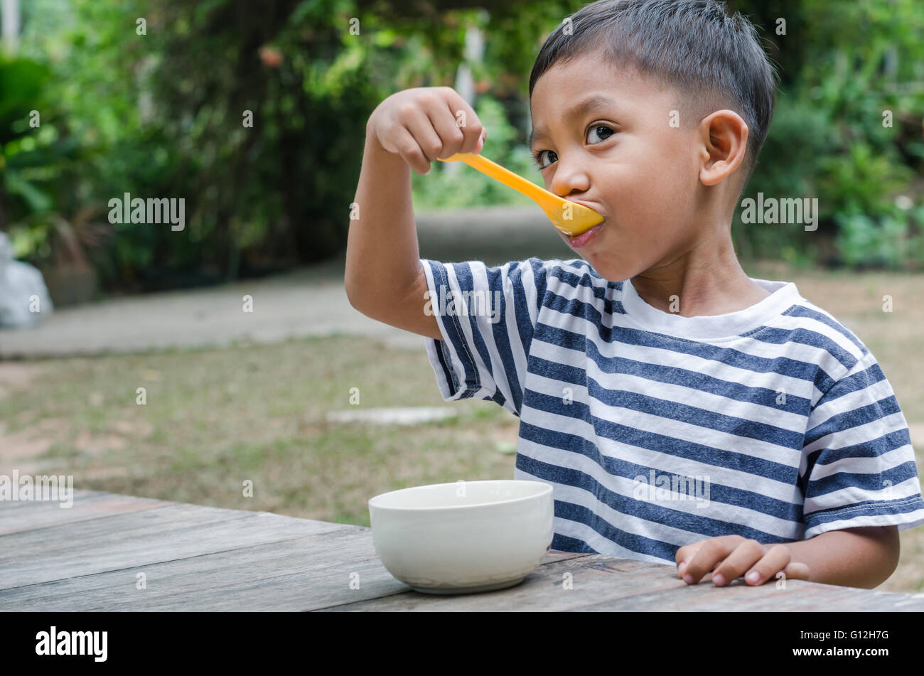 Manger le petit déjeuner enfant asiatique. Banque D'Images