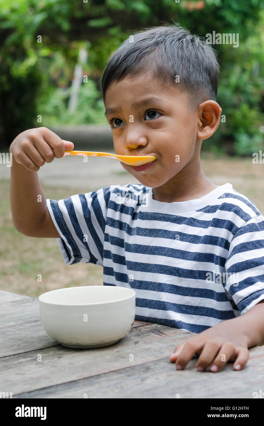 Manger le petit déjeuner enfant asiatique. Banque D'Images