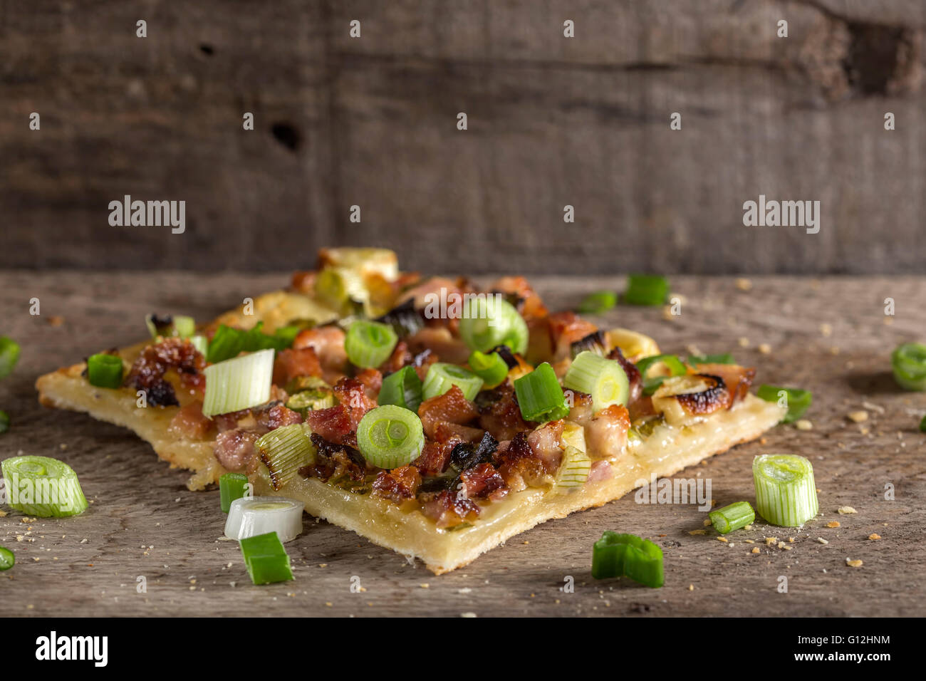 Tranche de pizza maison avec bacon et l'oignon vert sur fond de bois Banque D'Images