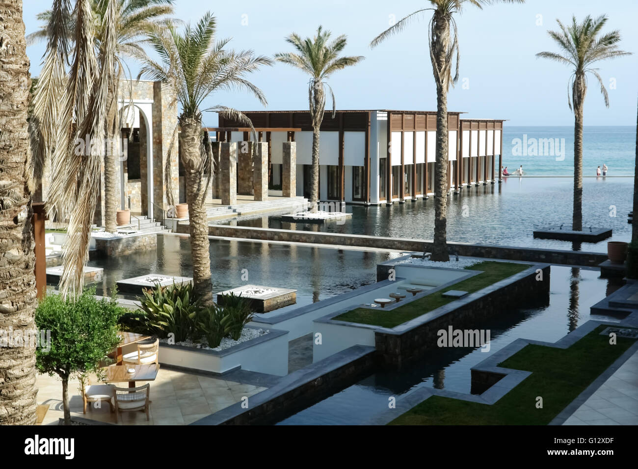 Héraklion, Crète, Grèce - 13 MAI 2014 : Le grand bleu piscine, bâtiment moderne avec des colonnes, des palmiers et de la plage dans l'hôtel Banque D'Images