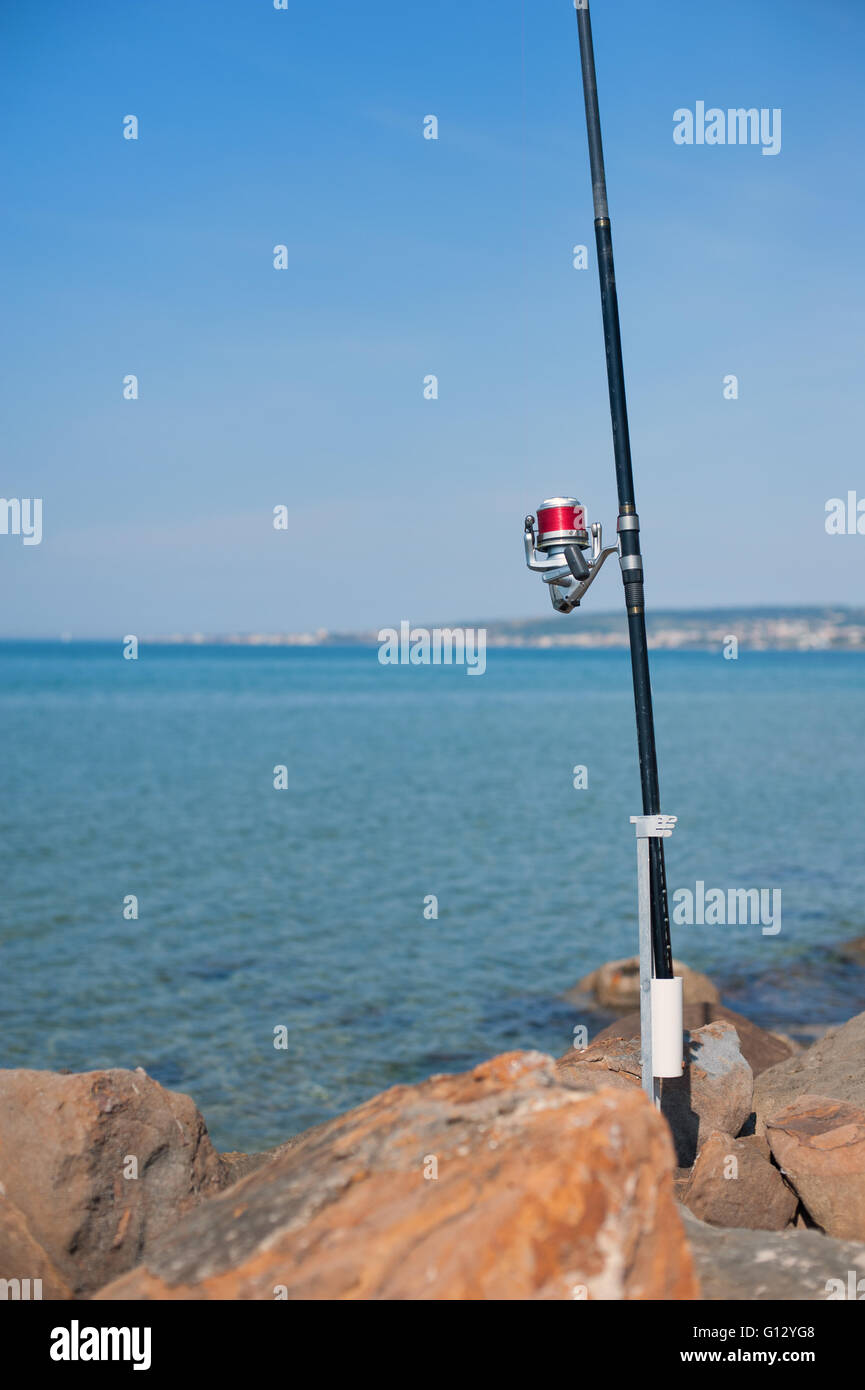 Canne à pêche avec détail du tambour rouge avec mer bleue et le ciel n'est pas mise au point historique Banque D'Images
