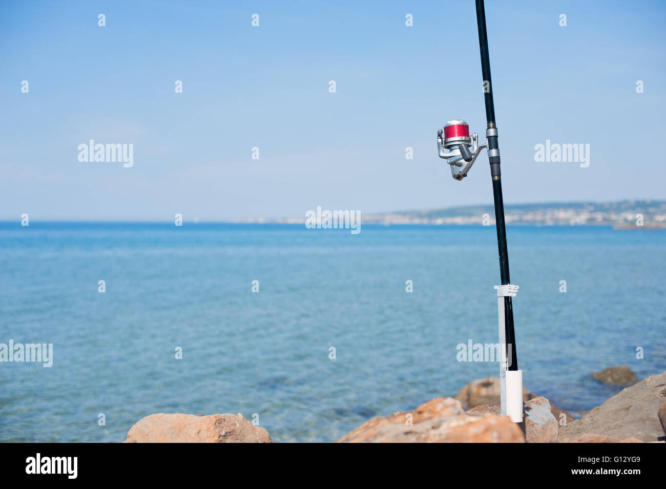 Canne à pêche avec détail du tambour rouge avec mer bleue et le ciel n'est pas mise au point historique Banque D'Images