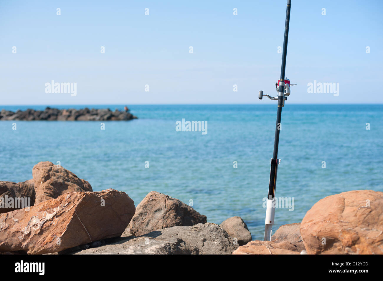 Canne à pêche avec détail du tambour rouge avec mer bleue et le ciel n'est pas mise au point historique Banque D'Images