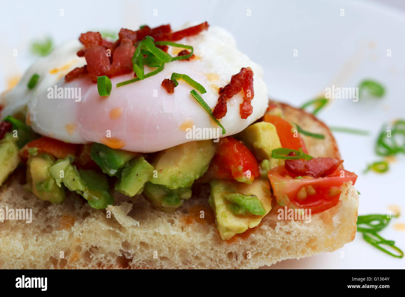 Œufs pochés tomates bacon et avocat sur toast Banque D'Images