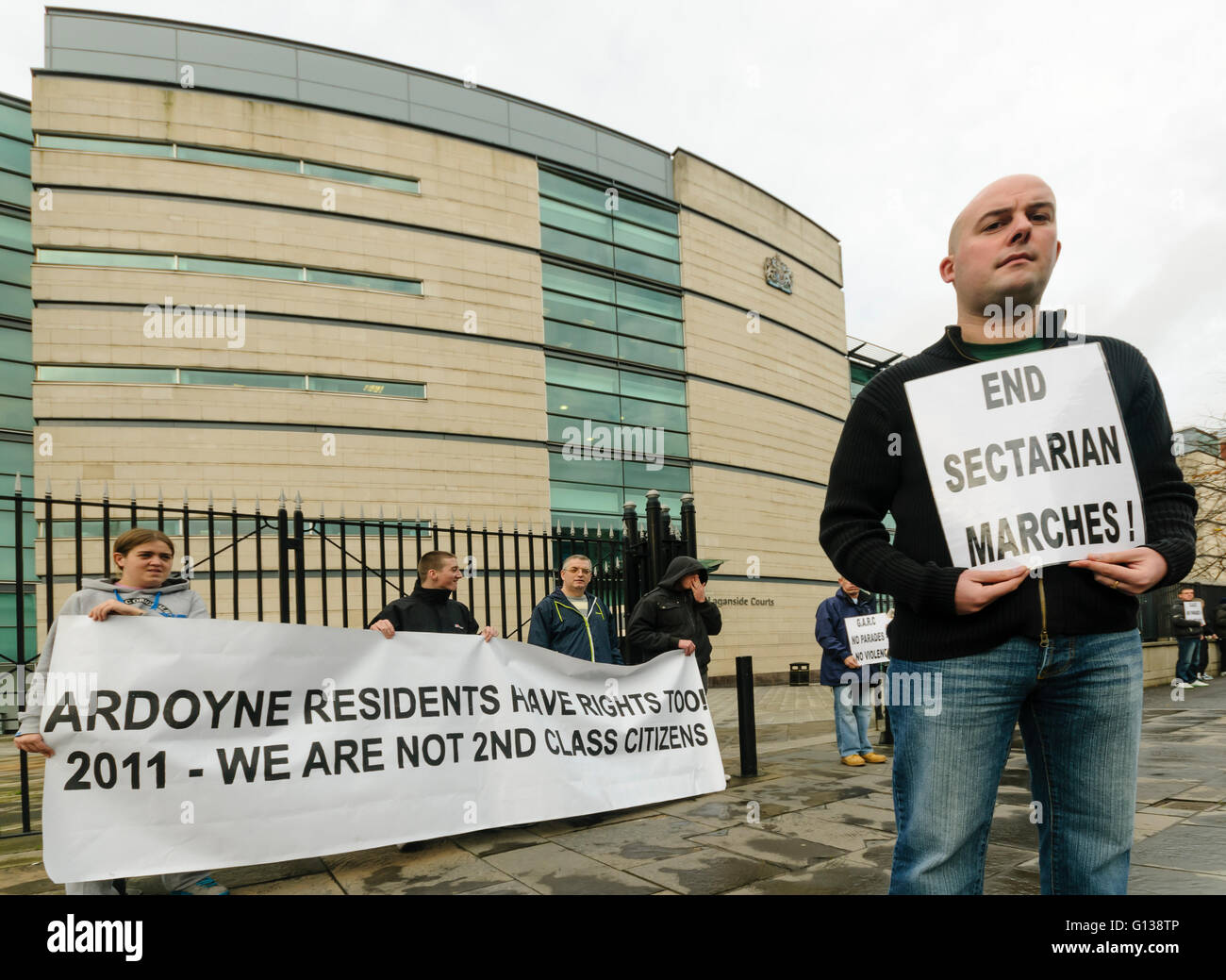 Belfast, Irlande du Nord. 31 Oct 2011 - Dee Fennell est titulaire d'une affiche appelant à mettre fin à des marches, comme le Comité des résidents plus Ardoyne (GARC) protester devant les tribunaux contre les procès de Laganside résidents arrêtés le 12 juillet pour tenter d'arrêter depuis mars Orange Ardoyne. Banque D'Images