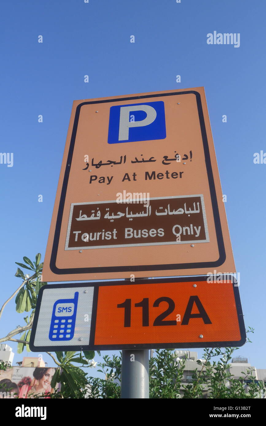Inscription en anglais et arabe indiquant payer au compteur, payer par téléphone et bus touristiques uniquement, Deira, Dubaï, Émirats Arabes Unis Banque D'Images