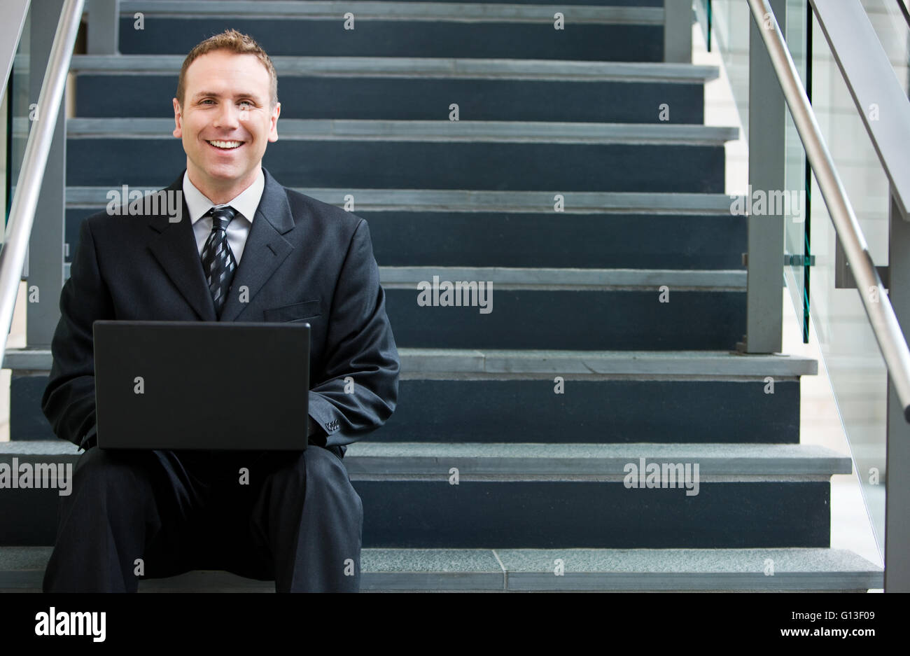 Businesspeople dans diverses poses par l'escalier en verre. Banque D'Images