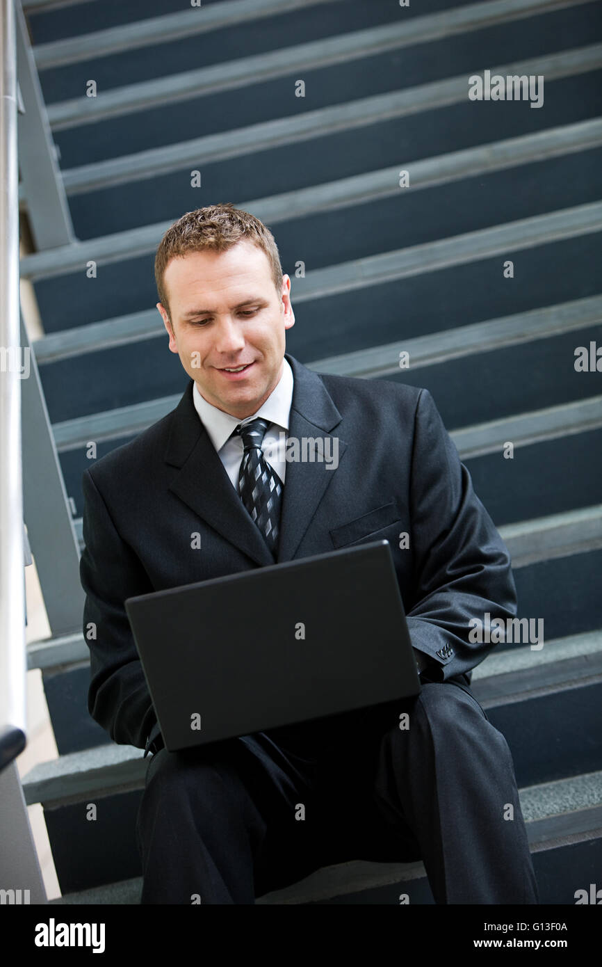 Businesspeople dans diverses poses par l'escalier en verre. Banque D'Images