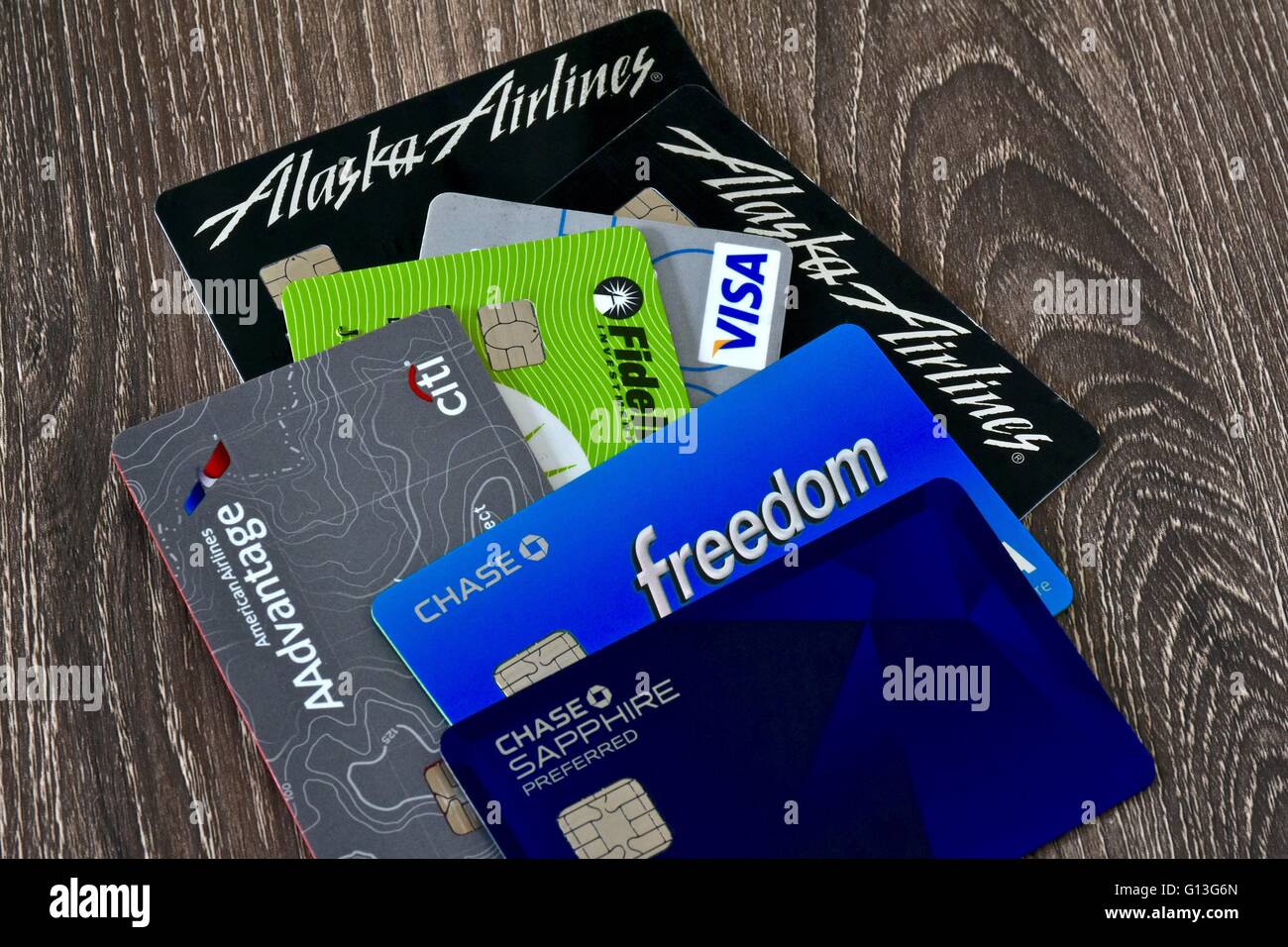 Une pile de cartes de crédit offrant des récompenses populaires sur une surface en bois Banque D'Images