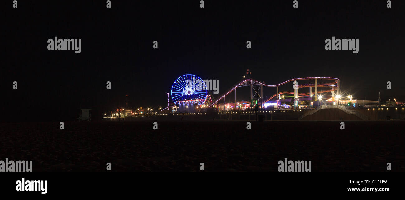 Santa Monica Pier boardwalk illuminé la nuit dans le sud de la Californie. Banque D'Images