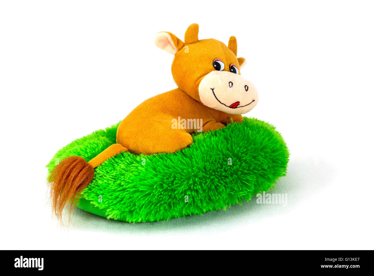 Peluche douce sous la forme d'un hippopotame allongé sur une pelouse verte Banque D'Images