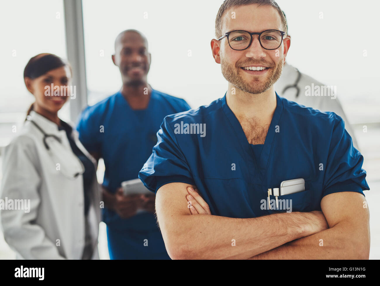 Jeune médecin en face de l'équipe de chirurgiens et médecins, looking at camera Banque D'Images