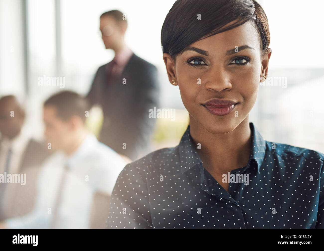 Close up on smiling beautiful business woman avec la lumière de la torche à partir de la grande fenêtre en fonctions avec group Banque D'Images