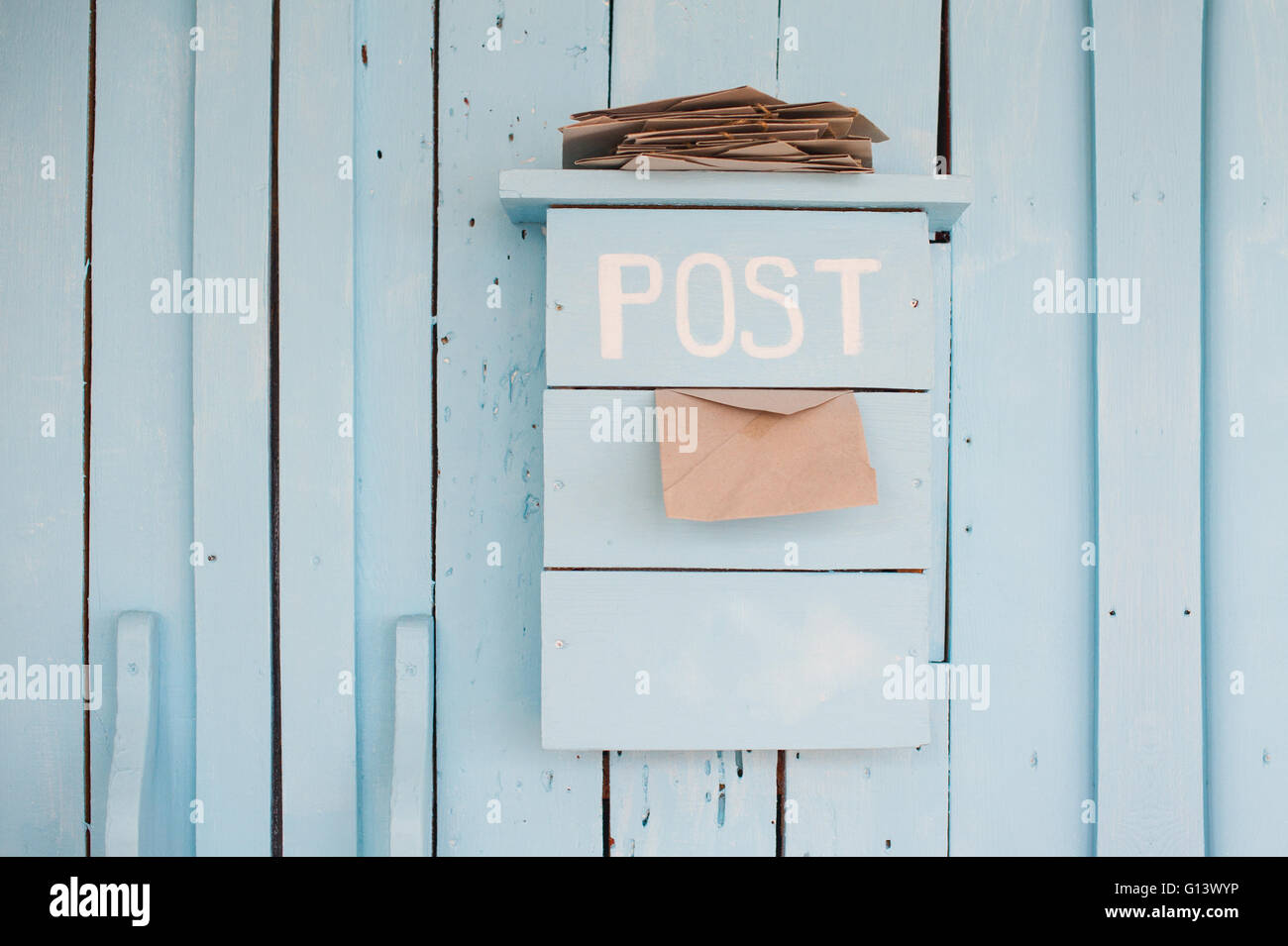 Boîte aux lettres avec des lettres dans un style vintage sur fond bleu en bois Banque D'Images