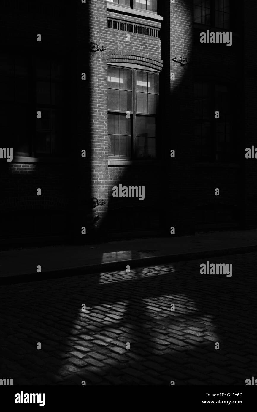 Rayon de soleil hits un bâtiment en brique sur un DUMBO street, à Brooklyn. Noir et blanc, Monochrome Banque D'Images