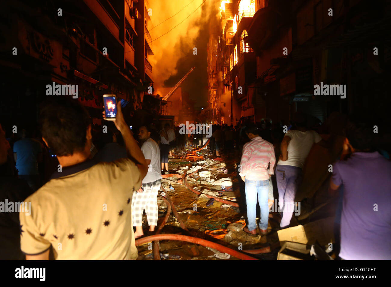 Le Caire, Égypte, au Caire. 8 mai, 2016. Les gens regardent les pompiers cessant l'incendie dans la nuit de dimanche à Attaba, marché le plus grand marché de l'Egypte au Caire, Egypte le 8 mai 2016. Credit : Ahmed Gomaa/Xinhua/Alamy Live News Banque D'Images