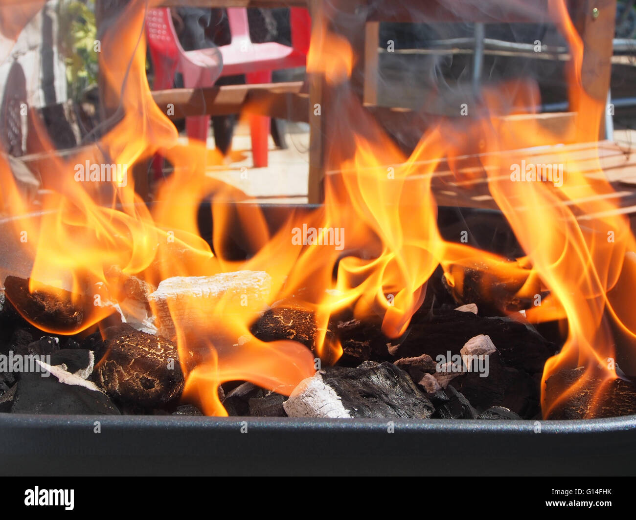 Le charbon de bois brûlant avec des flammes d'un barbecue Banque D'Images