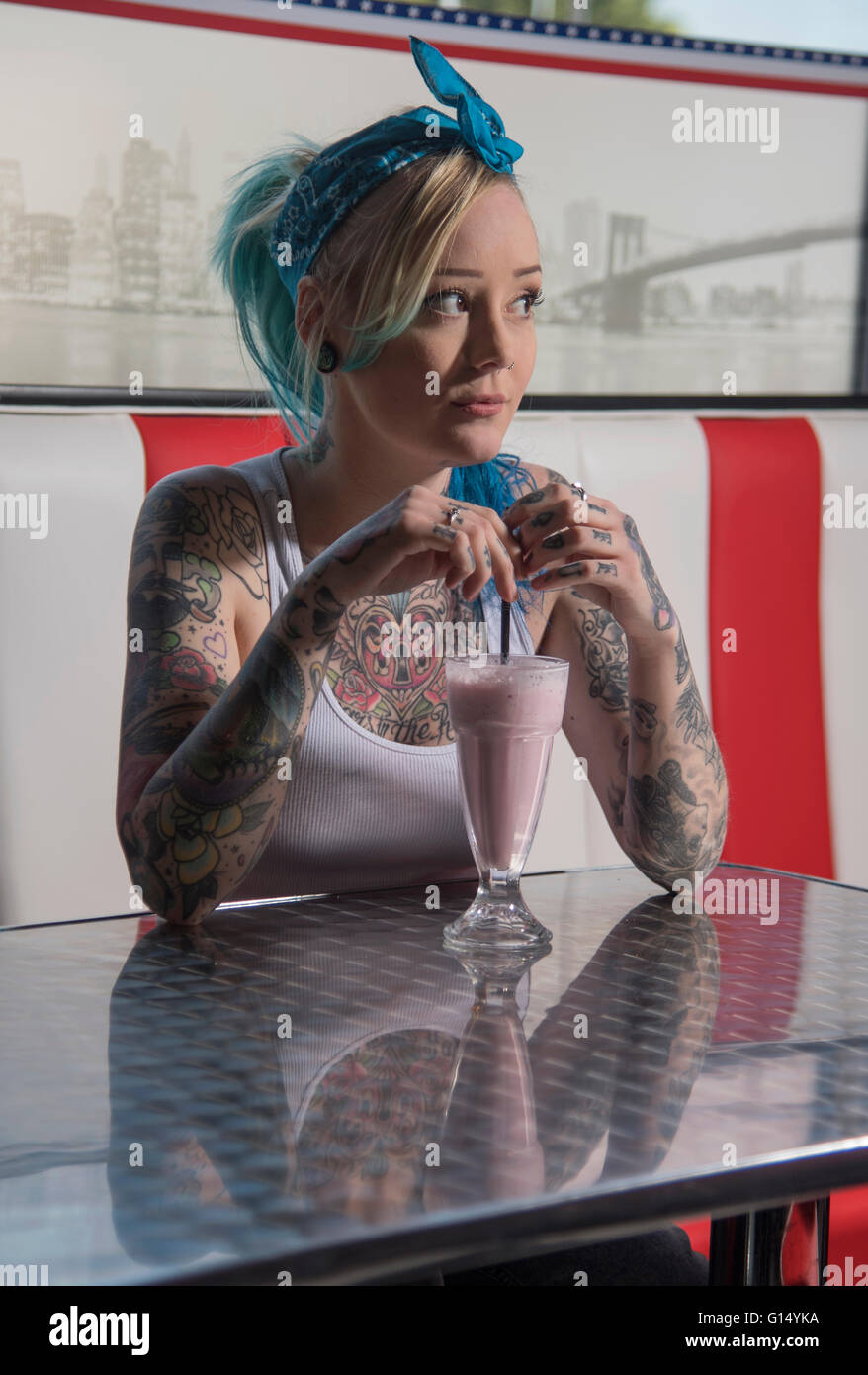 Fille tatouée en gang vêtements de style rétro dans un restaurant américain Banque D'Images