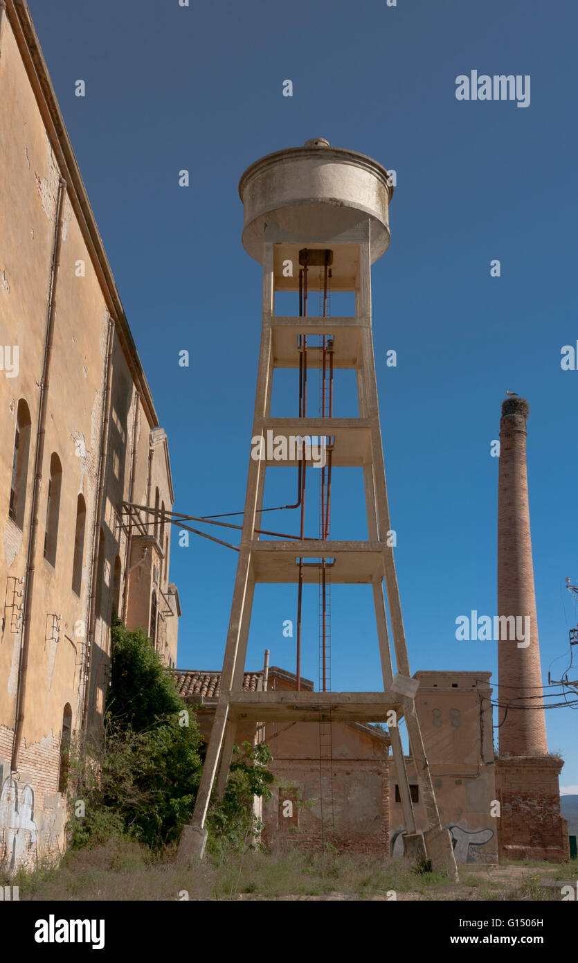 Un abandonated ancienne, ancienne tour de l'eau près d'une cheminée Banque D'Images